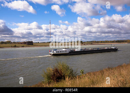 cargo vessel on the river Rhine, on the left the remains of the old railway bridge, Wesel, Germany.  Frachtschiff auf dem Rhein, links die Ueberreste  Stock Photo