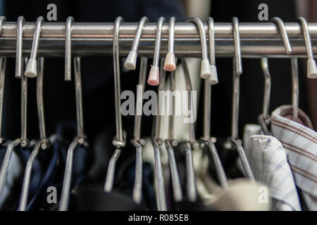 Clothes hangers on clothes rack Stock Photo