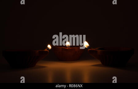 Diwali terracotta diyas on dark background which are used lighting up the house during diwali times Stock Photo