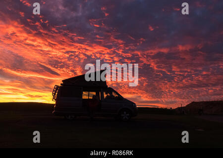 vw camper van silhouetted against brilliant red sunset, Crail, Fife, Scotland, UK Stock Photo