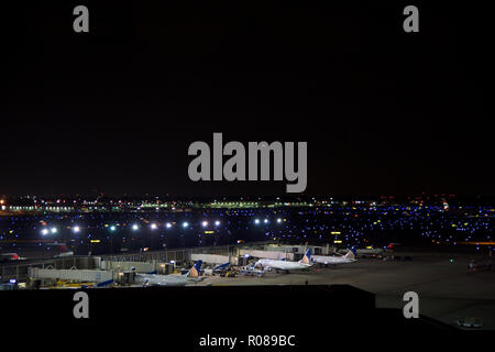 CHICAGO, ILLINOIS, UNITED STATES - MAY 11th, 2018: Several airplanes at the gate at Chicago O'Hare International Airport at night.
