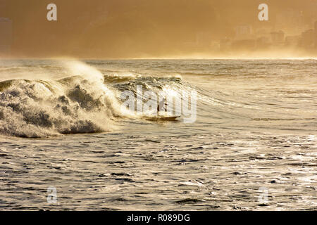 Silhouette of surfer on Ipanema beach during summer sunset Stock Photo