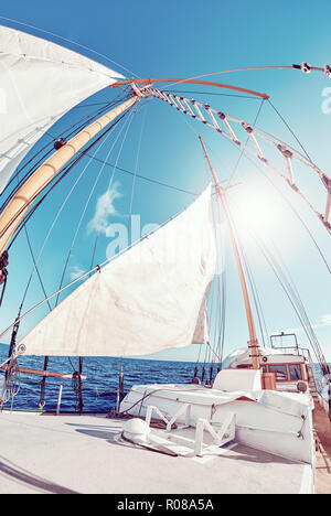 Fisheye lens view of an old schooner sails against the sun, color toned picture. Stock Photo
