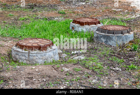 Covered sewer manholes on the city street Stock Photo