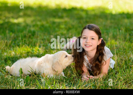Girl and dog laying on grass Stock Photo