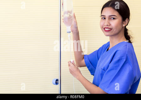 nurse puts the patient medical drip saline with free copyspace Stock Photo