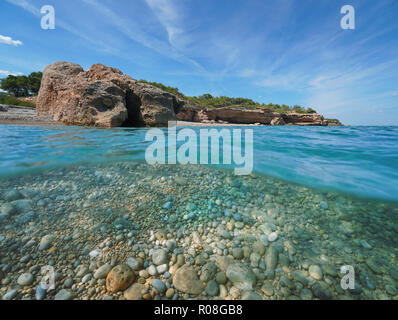 Pebble beach with rocky coast, split view half above and underwater surface, Cala Xelin, Mediterranean sea, L'Ametlla de Mar, Costa Dorada, Spain Stock Photo