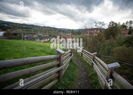 Narrow gravel footpath between two wood fences. Stock Photo