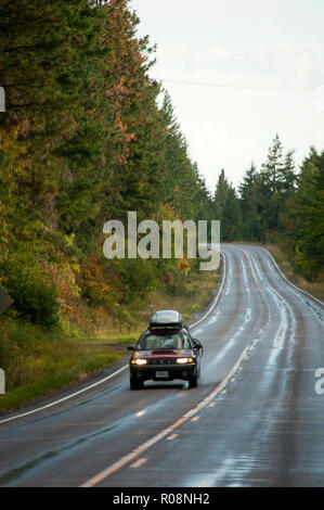 Car driving on wet road in autumn near Flathead Lake, Montana Stock Photo
