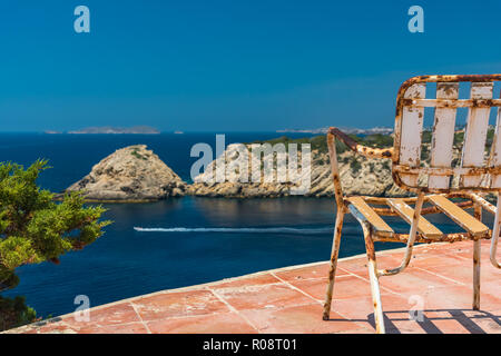 The old rusty chair and the fantastic view at ibiza Stock Photo