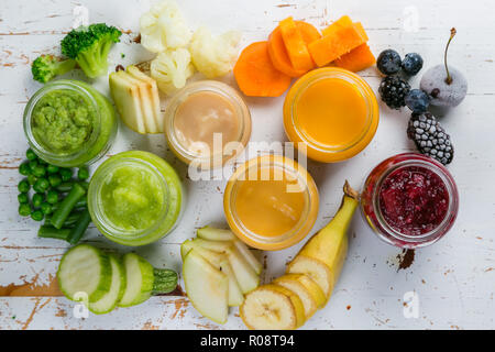 Colorful baby food purees in glass jars with ingredients. Healthy organic baby food concept. Starting solid food, delivery, top view, above, overhead,