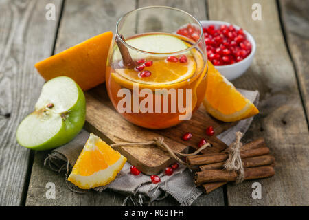 Mulled wine with oranges, pomegranate, rustic background Stock Photo