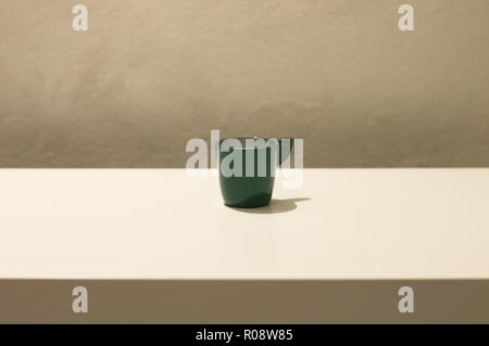 Isolated green coffee cup on a white table (Pesaro, Italy, Europe)	 Isolated green coffee cup on a white table (Pesaro, Italy, Europe) Stock Photo