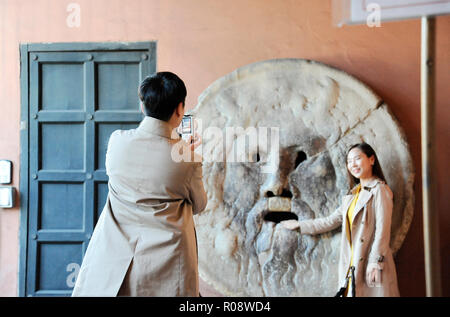 Rome, Italy – October 10, 2018: Asian man and woman photograph each other in front of the mouth of truth (Bocca della Verità). Church of Santa Maria i Stock Photo