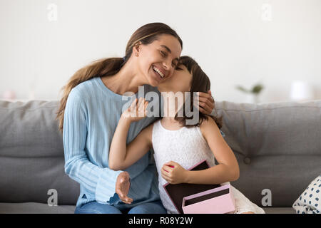Grateful daughter receives from mother gift kissing her Stock Photo