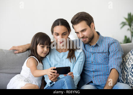 Family spend free time watching video on mobile phone Stock Photo