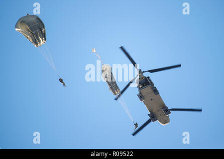 Army paratroopers assigned to the 4th Infantry Brigade Combat Team (Airborne), 25th Infantry Division, U.S. Army Alaska, jump from a CH-47 Chinook helicopter during airborne training at Joint Base Elmendorf-Richardson, Alaska, Nov. 1, 2018. The Soldiers of 4/25 belong to the only American airborne brigade in the Pacific and are trained to execute airborne maneuvers in extreme cold weather and high altitude environments in support of combat, partnership and disaster relief operations. Army aviators from B Company, 1st Battalion, 52nd Aviation Regiment out of Fort Wainwright, operated CH-47 Chin Stock Photo