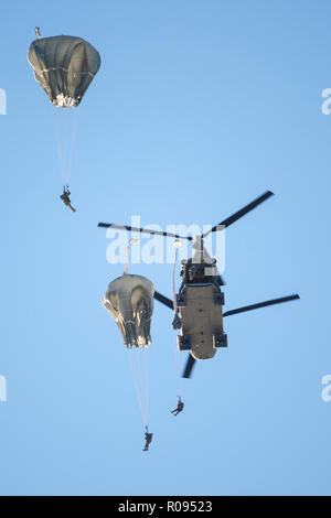 Army paratroopers assigned to the 4th Infantry Brigade Combat Team (Airborne), 25th Infantry Division, U.S. Army Alaska, jump from a CH-47 Chinook helicopter during airborne training at Joint Base Elmendorf-Richardson, Alaska, Nov. 1, 2018. The Soldiers of 4/25 belong to the only American airborne brigade in the Pacific and are trained to execute airborne maneuvers in extreme cold weather and high altitude environments in support of combat, partnership and disaster relief operations. Army aviators from B Company, 1st Battalion, 52nd Aviation Regiment out of Fort Wainwright, operated CH-47 Chin Stock Photo