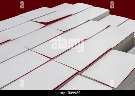 Group of white blank book covers on the table isolated on red background Stock Photo