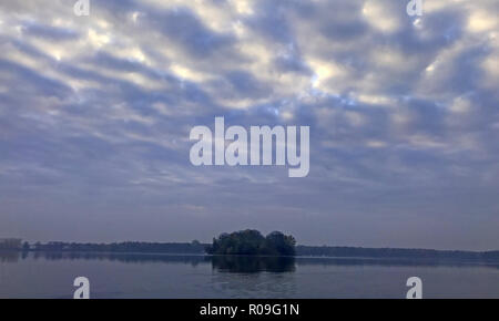 Berlin, Germany. 03rd Nov, 2018. The sun rises behind a thick cloud cover over the Tegeler Lake. Credit: Paul Zinken/dpa/Alamy Live News Stock Photo