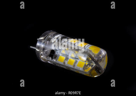 Close-up view of a modern bipin G4 socket LED lamp on black background demonstrating modern eco energy saving technology Stock Photo