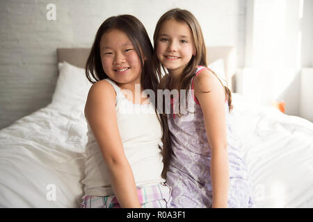 The Two little girls lying on bed at home Stock Photo