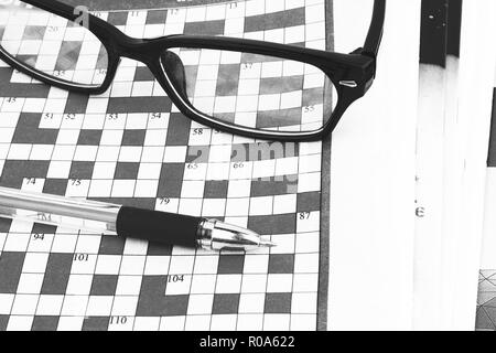pen lying on a blank crossword to be filled Stock Photo