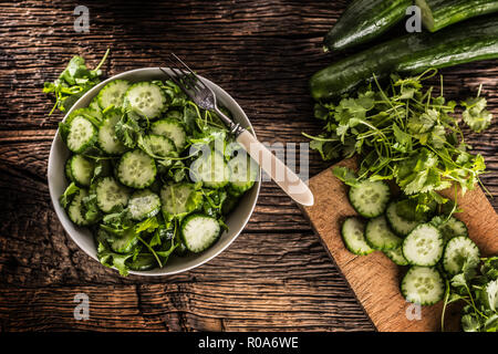 Sliced cucumber on a plate with parsley herb on rustic oak wood. Stock Photo