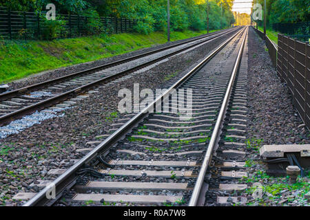 two endlessly long train railroads with the tracks vanishing in the distance horizon amazing transportation or traveling background Stock Photo