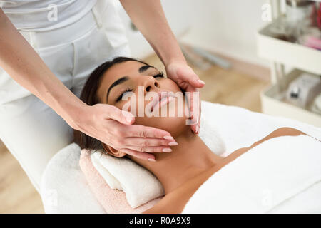 Arab woman receiving head massage in spa wellness center. Beauty and Aesthetic concepts. Stock Photo