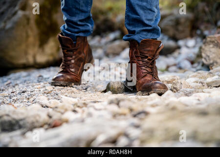 Hikers walking boots in front of a river valley Stock Photo