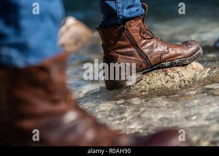 Hikers walking boots in front of a river valley Stock Photo