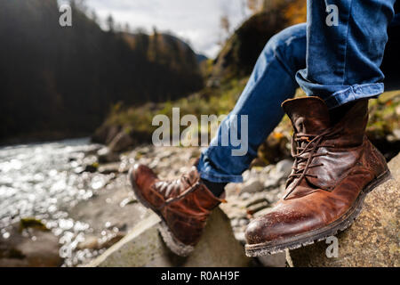 Hikers walking boots in front of a river valley Stock Photo