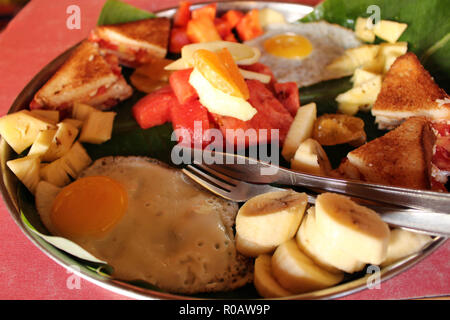 The Indian style breakfast or dessert served with egg, bread, and fruit. Stock Photo