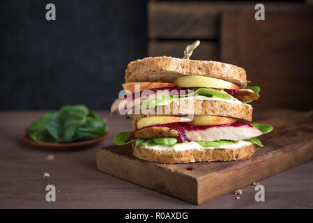Turkey or Chicken Leftover Sandwich with stuffing and cranberry sauce. Freshly made from Thanksgiving or Christmas turkey leftovers on crusty wholemea Stock Photo