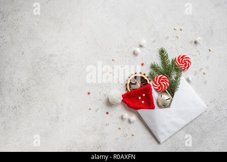 Christmas composition with sweets, fir branch, ornaments and envelop, flat lay on white, copy space. Christmas greeting card, desigh, concept. Stock Photo