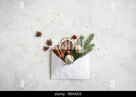 Christmas composition with spices, fir branch, ornaments and envelop, flat lay on white, copy space. Christmas greeting card, design, concept. Stock Photo