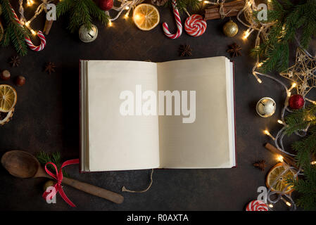Empty Cookbook for Christmas recipes on dark table. Cook book with festive Christmas decor and spices. Stock Photo