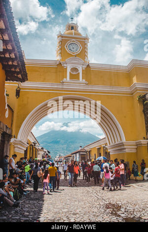 Crowds gathering to take pictures around the famous landmark yellow Arch of Santa Catalina in Antigua Guatemala
