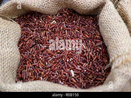 Heap of Uncooked Deep Purple Color Rice-berry Rice in a Natural Hemp Sack Stock Photo