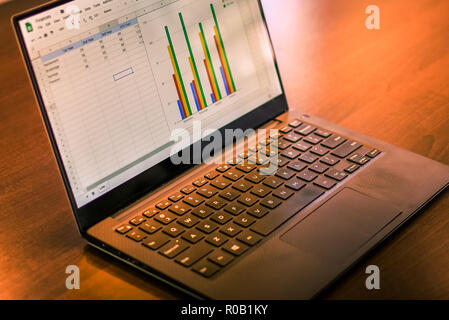 Computer with graph background on a desk Stock Photo