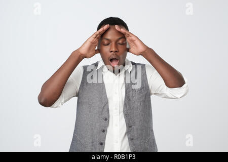 African young man, slapping hand on head having a duh moment isolated on gray background. Stock Photo