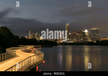 Lighted sections of the boardwalk on a newly constructed walking and running trail shine along the shores of Lady Bird Lake in downtown Austin, Texas Stock Photo