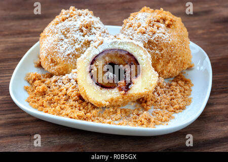 Plum dumplings on wooden table Stock Photo