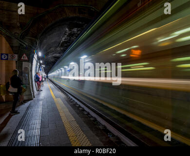 High-speed night train passing through a train station Stock Photo