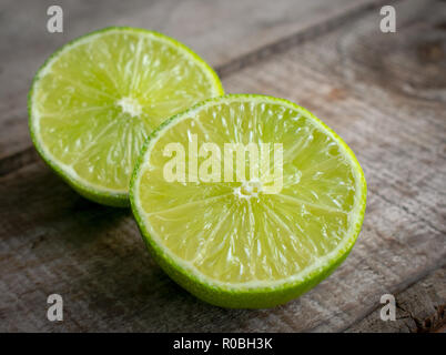 Fresh juicy lime cut in half on a wooden background, close-up Stock Photo