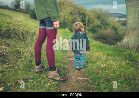 A young mother and her toddler are walking in the countryside Stock Photo
