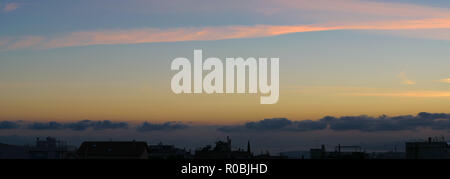 Sunset panorma with cityscape in dark shadow, blue orange soft colors Stock Photo