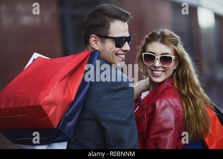 Picture showing young couple shopping in the city. Portrait of a couple with shopping bags in the city.People, sale, love and happiness concept. Stock Photo