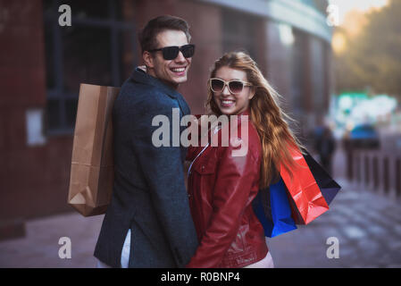 Picture showing young couple shopping in the city. Portrait of a couple with shopping bags in the city.People, sale, love and happiness concept. Stock Photo
